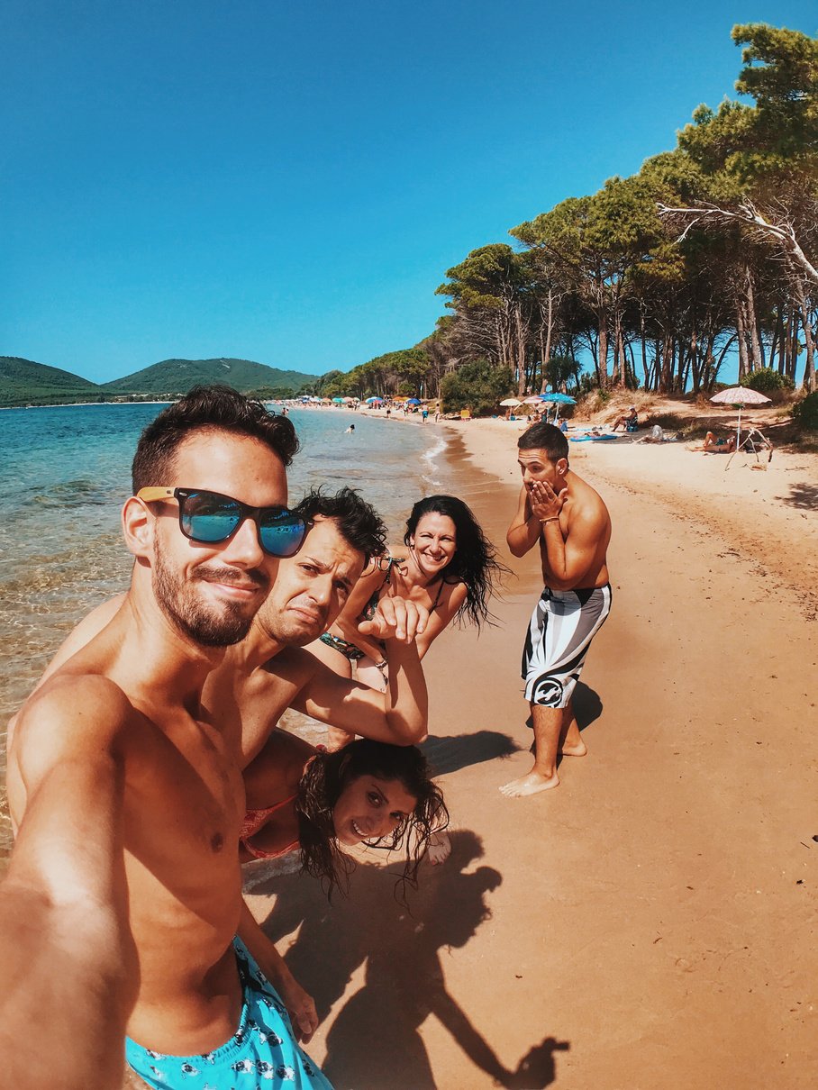 Men And Women At The  Beach Taking Photo